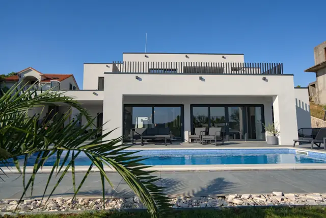 Pool, palm leaves and covered villa terrace