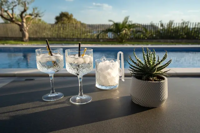 Cocktail glasses and ice bucket on the poolside table