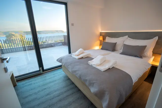 Sea-view bedroom with pool and Adriatic visible through sliding glass doors