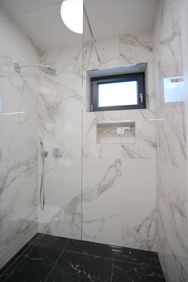 Walk-in rain shower with marble walls