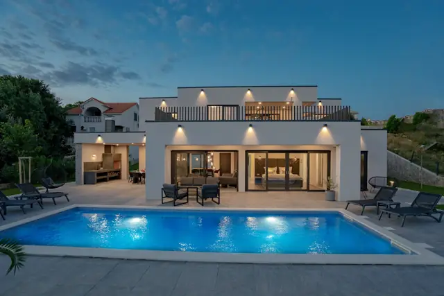 Illuminated private pool and villa at blue hour