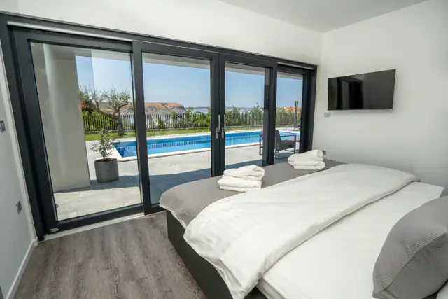 Ground-floor bedroom with sliding doors opening onto the pool terrace