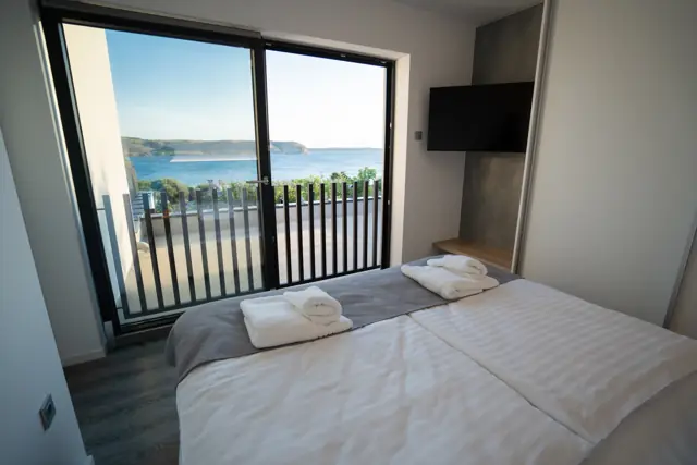 First-floor bedroom with balcony doors and open sea view