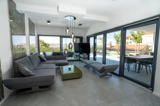 Bright lounge with large grey corner sofa and terrace access