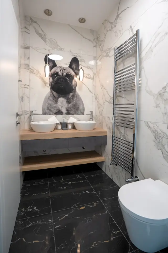 Marble bathroom with double vessel basins and French bulldog artwork