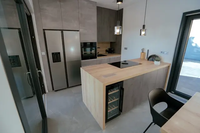 Modern kitchen with wooden island and integrated wine cooler