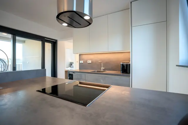 Kitchen island with stainless steel hood and concrete-look worktop