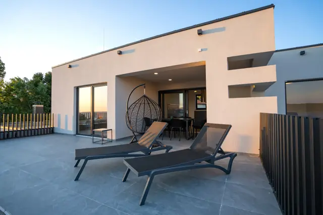 Evening on the covered terrace with lounge chairs by the villa