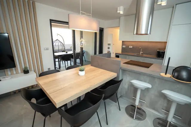 Dining nook and kitchen bar with stools, terrace beyond