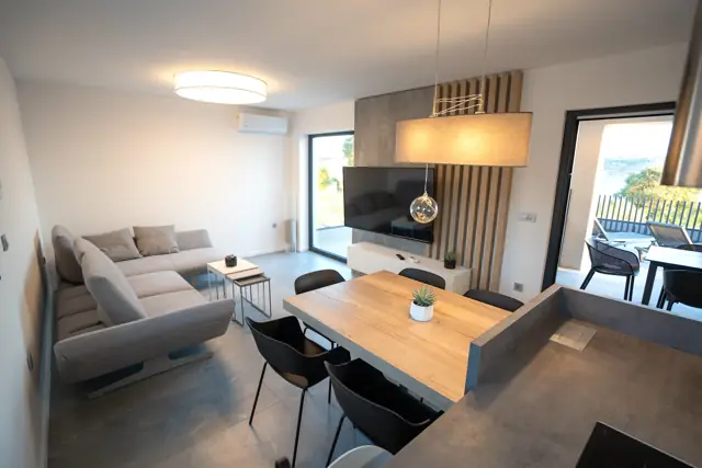 Living room with corner sofa, dining table and terrace access