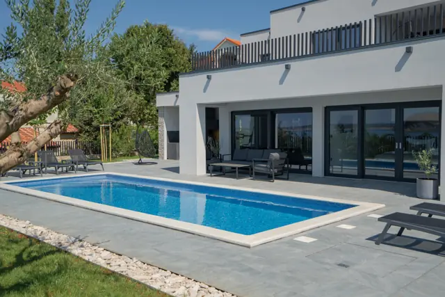 Heated pool and covered lounge terrace in daylight