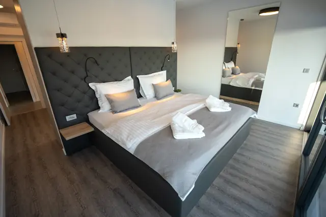 Double bedroom with quilted headboard, pendant lights and mirrored wardrobe