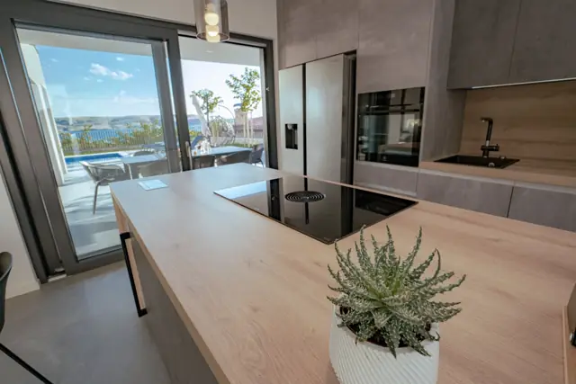 Kitchen island with induction hob and view to the pool terrace