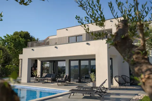 Poolside loungers and covered terrace framed by olive trees